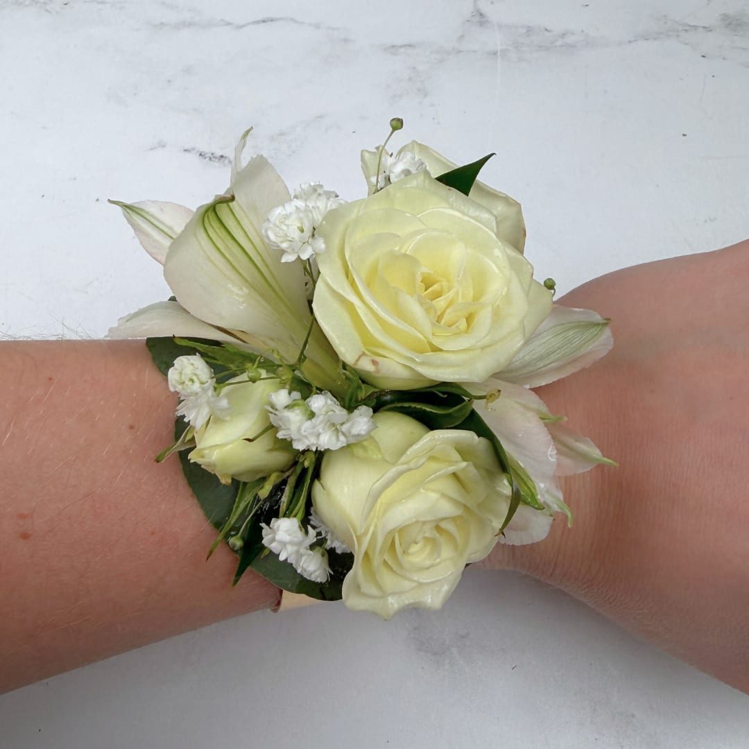 Elegant Ivory Corsage - The Elegant Ivory Corsage features four white/ivory spray roses and two alstroemeria with eucalyptus greens and delicate filler, artfully arranged on a wearable golden cuff. This design is elevated and sophisticated, created to enhance the beauty of the wearer and tie the whole outfit together. The golden cuff adds a unique touch that'll set this corsage apart from all of the others, and will help create memories that will be cherished forever.