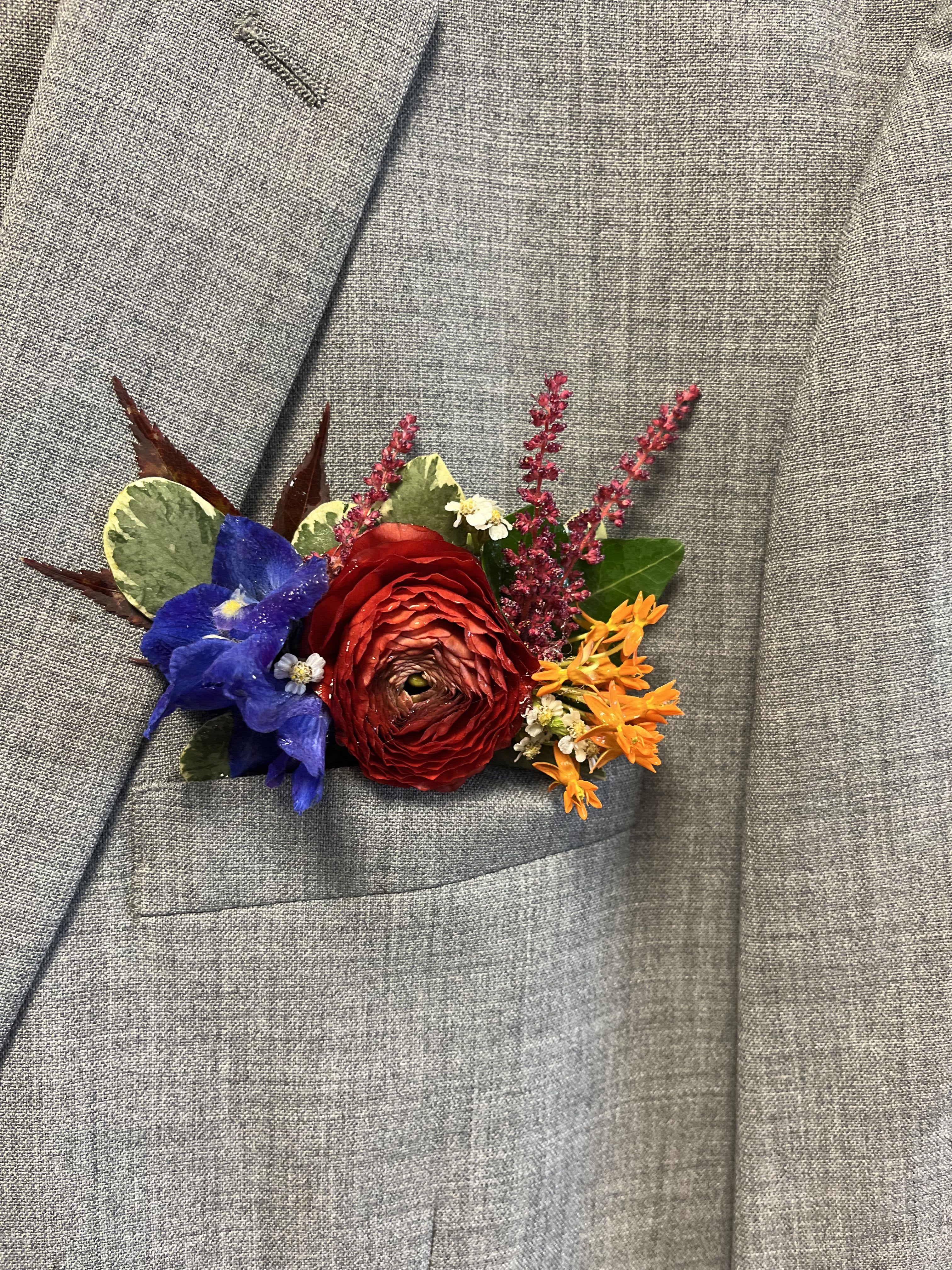 Colorful boutonniere pinned to a gray suit jacket