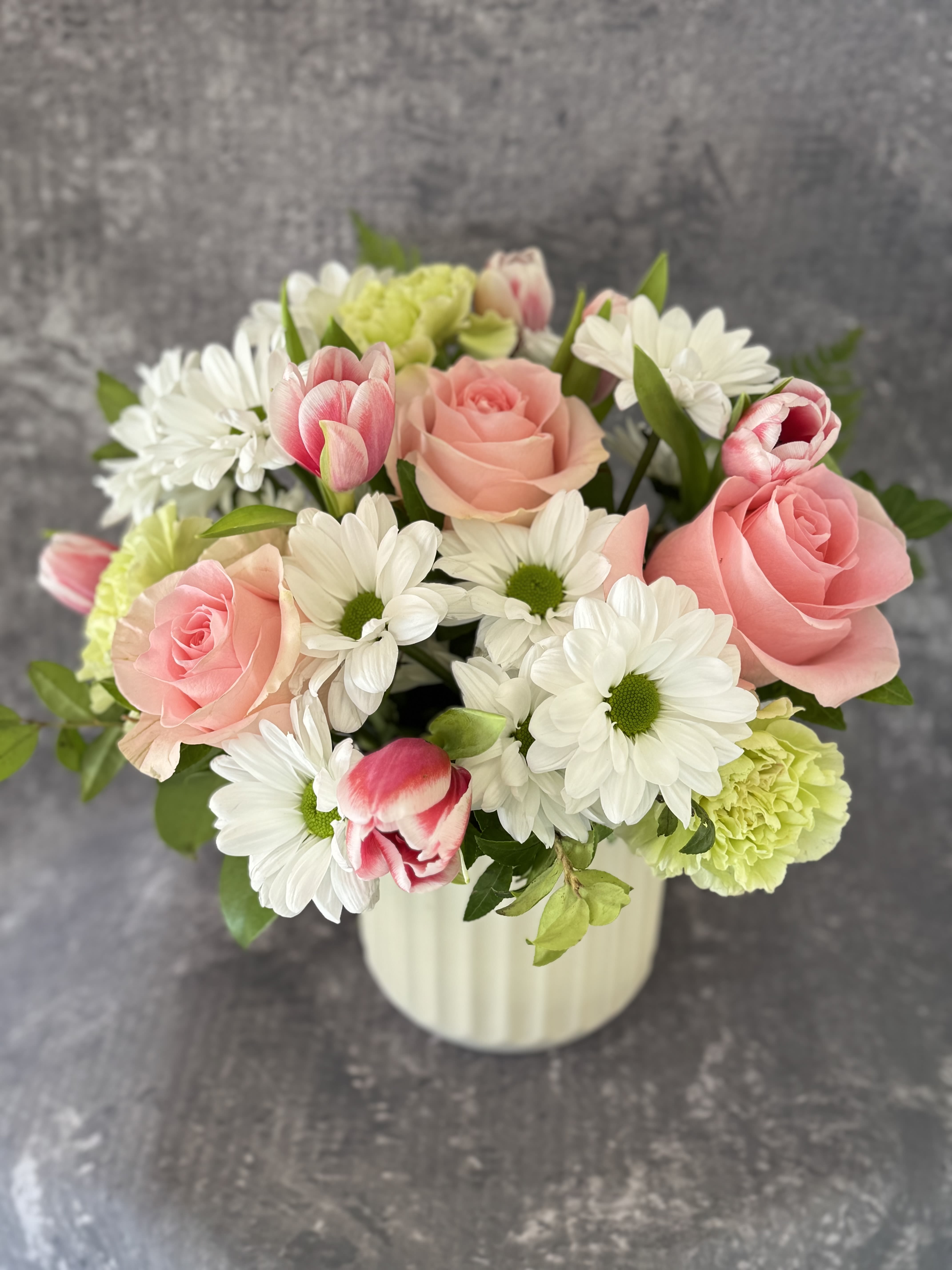 Pink roses and white daisies in a white vase