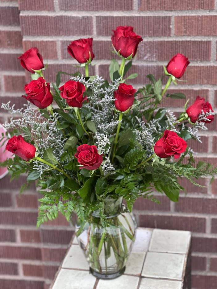 Red roses arranged in a clear glass vase