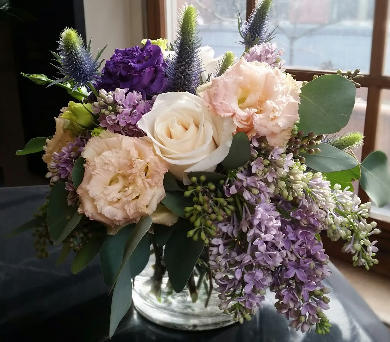 I Lilac You - A beautiful garden inspired arrangement featuring French Lilac, premium ivory Roses and the lacy Lisianthus in a clear glass cylinder.