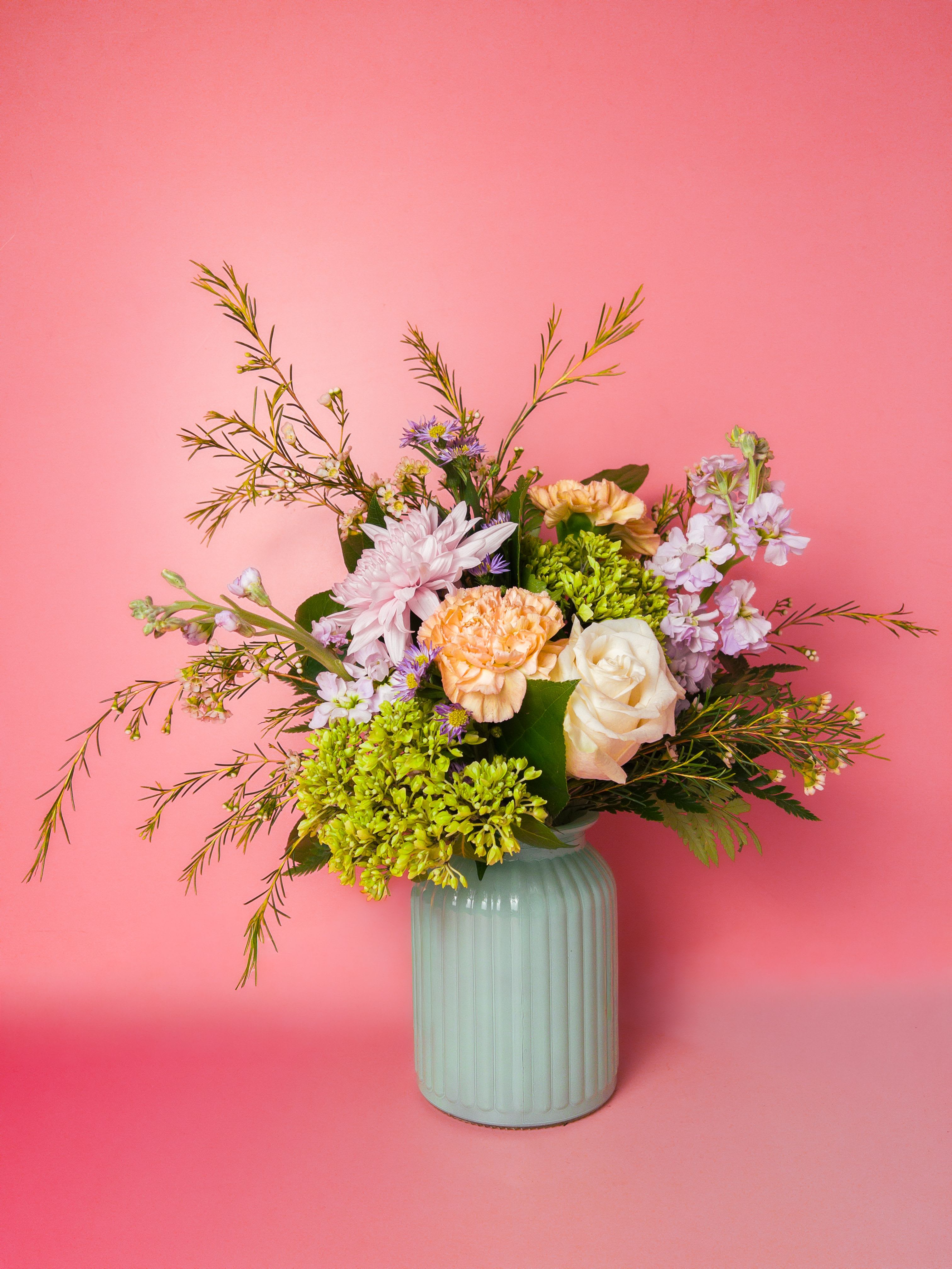Garden Muse Arrangement - Inspired by the peaceful beauty of a blooming garden, Garden Muse features a fresh mix of white, purple, peach, and green flowers designed in a soft seafoam vase. This Mother’s Day arrangement offers a natural, garden-inspired look that feels elegant, fresh, and timeless. Its gentle color palette makes it ideal for moms who appreciate soft, classic floral styles. As a leading Baltimore Florist, we create thoughtfully designed seasonal arrangements perfect for celebrating Mother’s Day. Our convenient Flower Delivery in Baltimore allows you to share beautiful flowers with loved ones across the city with ease.