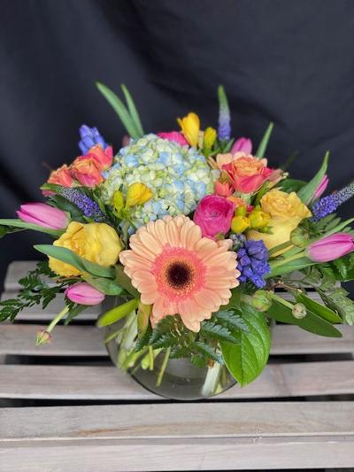 Mixed bouquet with a peach gerbera daisy in a glass vase