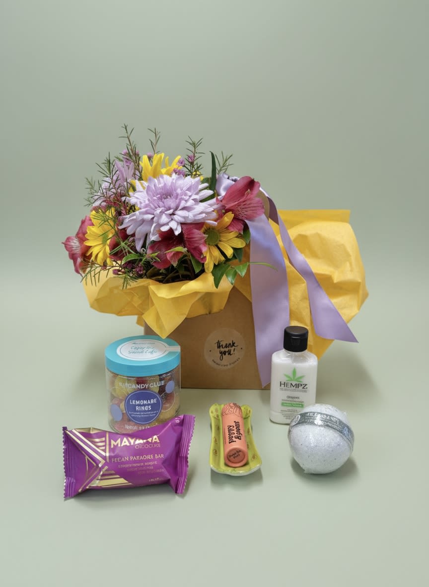 Mixed flower bouquet in a gift bag with assorted treats and a lotion bottle
