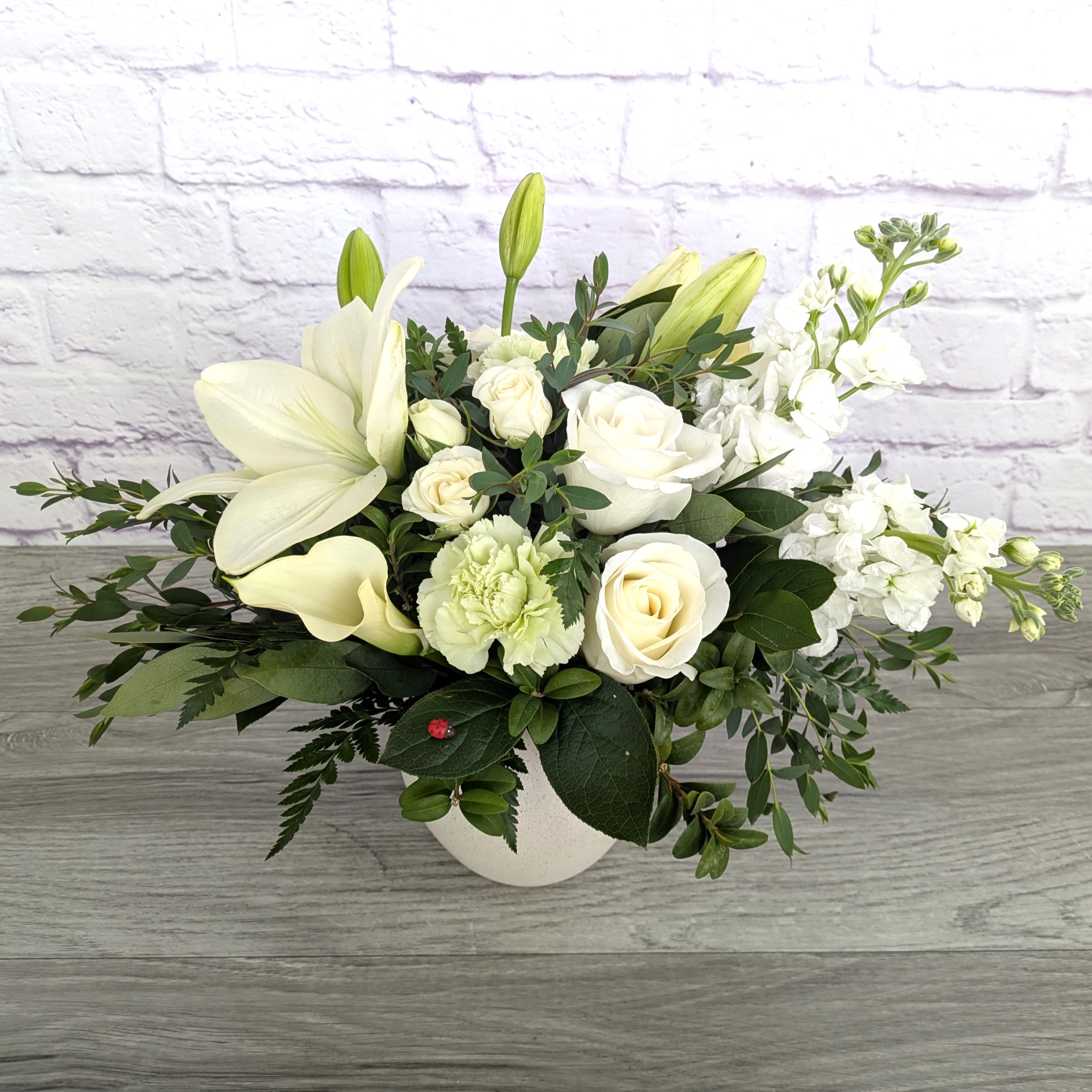 Zen garden - Zen garden is A Ladybug Floral exclusive bouquet. This bouquet includes asiatic lilies, cala lilies, roses, stock, carnations, spray roses, bay leaf and eucalyptus. Featured in a 5.5” stone inspired concrete bowl.  Orientation: All Around 13” Tall 18” Wide  