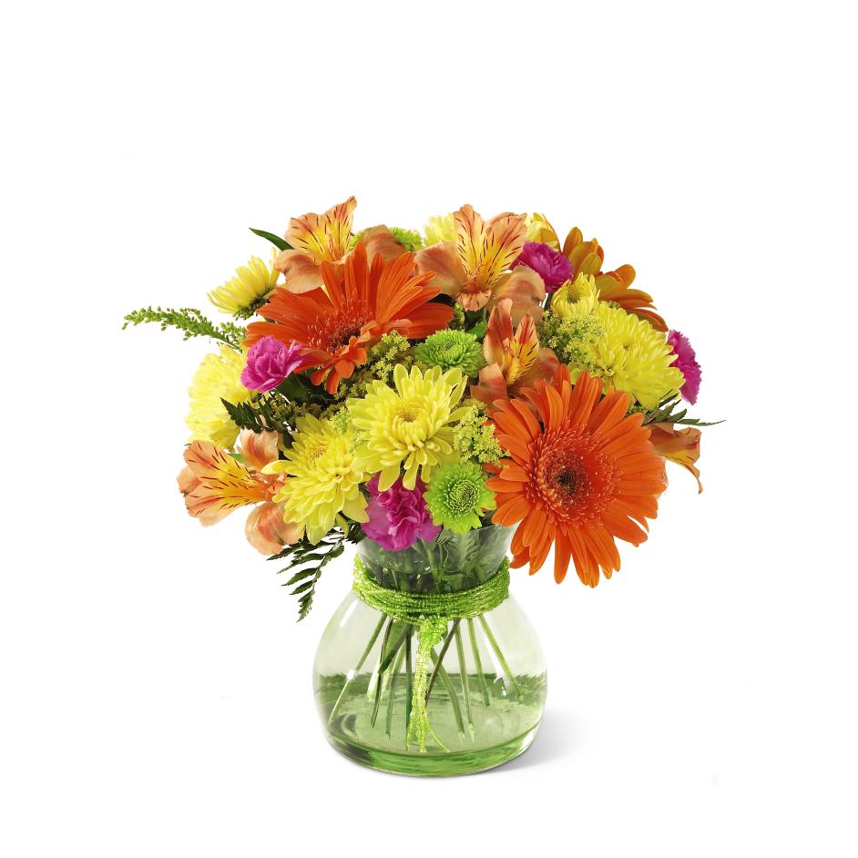 Bright mixed bouquet in a round glass vase with a green ribbon