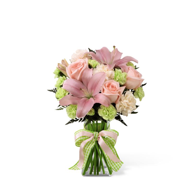 Pink lilies and roses in a glass vase with a ribbon bow