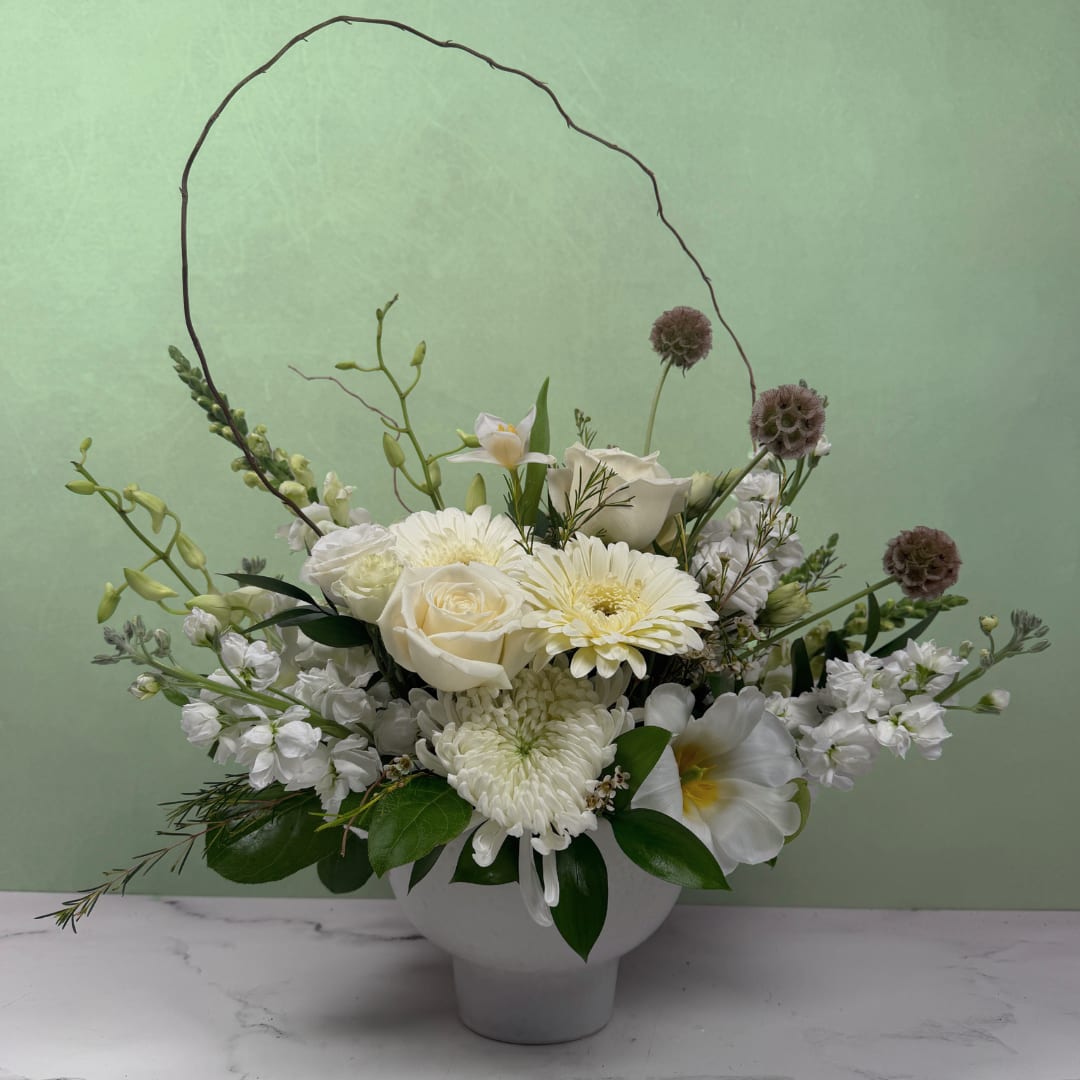 Fresh &amp; Elegant Compote - A full, abundant mix of elegant white and green blooms designed to look clean and classy with a modern feel. Each arrangement is thoughtfully created using the freshest seasonal flowers for a rich, lively design.  Styled in a compote vessel, this arrangement has a wide, lush shape that feels bold and expressive.  Available in three sizes. For the most impressive and luxurious look, select the Premium option.  Dimensions approximately L 20" x H 20"