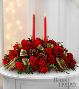Red floral centerpiece with two red taper candles and striped ribbon