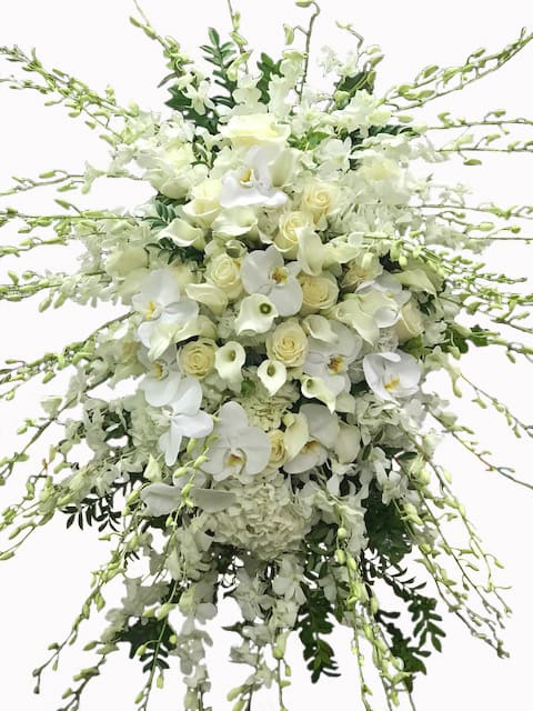 Large cascading white spray with roses, orchids, calla lilies, and hydrangeas