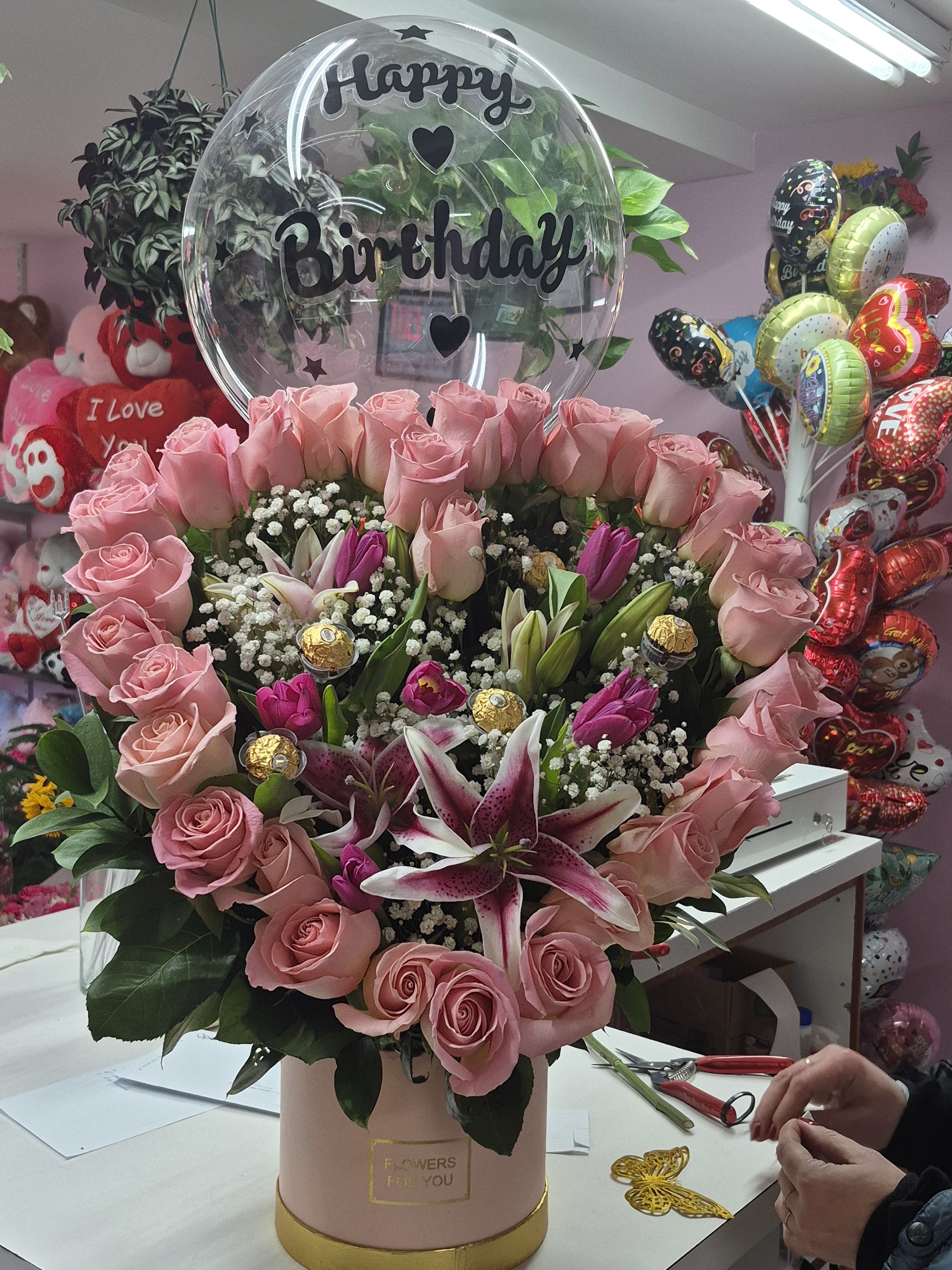 Pink Dream - "A masterpiece of elegance and whimsical charm."  This stunning arrangement is a true celebration of beauty, blending the soft grace of premium pink roses with the vibrant energy of stargazer lilies. Artfully curated in a sophisticated blush-toned box, the design is accented with decadent Ferrero Rocher chocolates and a clear "Happy Birthday" bubble balloon. It is the perfect gift to turn any birthday into a dream come true.