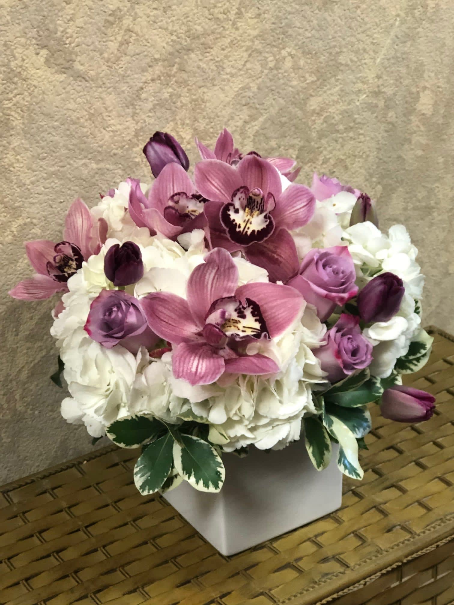 Vienna, Austria - Type of Flowers: White Hydrangeas, Purple Cymbidium Orchids, Lavender Roses, Purple Tulips,  in a square ceramic vase. Availability: All year round Substitute Available: Yes Design View: All Facing View Photo shown: Regular