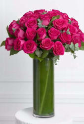 36 Hot Pink Roses in a Glass Vase - A vibrant and eye-catching arrangement featuring 36 premium hot pink roses, designed in a beautiful spiral style for a lush, full look. Accented with fresh eucalyptus, this design brings a touch of natural elegance and freshness.  The clear glass vase is artfully lined with aspidistra leaves (tropical foliage), creating a clean, modern presentation that enhances the bold color of the roses.  Perfect for celebrations, birthdays, or to brighten someone’s day with a sophisticated and lively floral statement.  Includes:  36 hot pink premium roses Fresh eucalyptus accents Glass vase lined with aspidistra leaves  A stunning arrangement that blends elegance, texture, and vibrant color. 