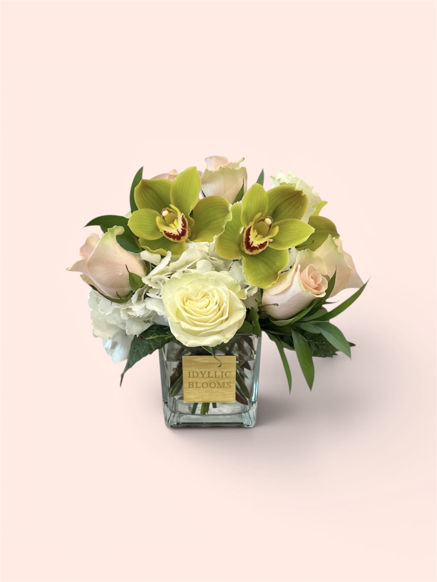 Posh &amp; Elegant  - A refined and modern composition, Posh Elegance is the definition of understated luxury. Featuring striking green cymbidium orchids as the focal point, this arrangement is softened with creamy white roses, blush-toned roses, and lush white hydrangea. Clean lines and a compact shape give it a polished, high-end feel—perfect for upscale gifting, sympathy, or minimalist lovers.  Designed in a sleek glass cube with a signature label, this piece speaks quiet sophistication without trying too hard.