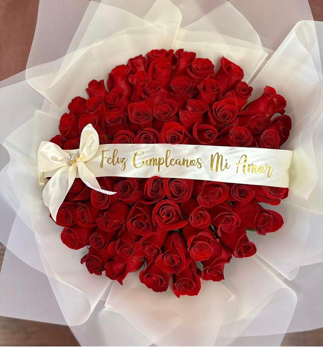 Bouquet of red roses wrapped in white paper with a ribbon
