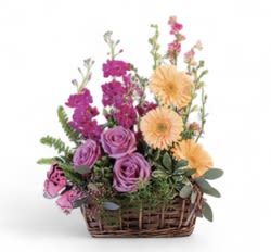 Summer Meadow - Bring home some warmth with this beautiful design! Peach gerberas, lavender roses, and pink larkspur are as precious as the wildflowers in the meadow. Like a soothing breeze on a warm summer day, Summer Meadow is a lovely basket that's bursting with charming blooms!  Includes: Wicker Basket, Butterfly, Greens: Seeded Eucalyptus, Variegated Pittosporum, Leatherleaf, Sword Fern, Asparagus Fern, Flowers: Peach Gerberas, Purple Stock, Lavender Roses, Pink Delphiniumlarkspur, Green Hypericumva.