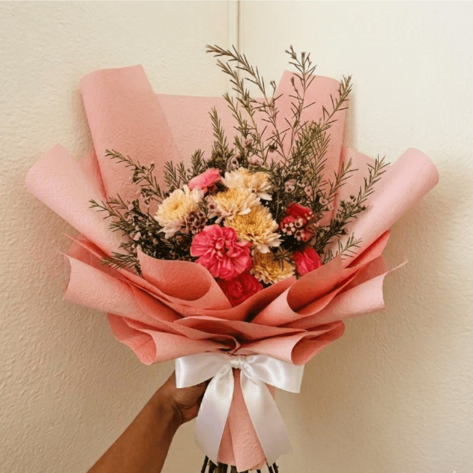 Velvet Sunset - Rich, textural, and warm—Velvet Sunset captures the magic of a twilight horizon. Featuring the intricate, velvet-like layers of ranunculus and soft peach mums, this design offers a sophisticated artistic flair for the partner who appreciates the finer details.  This seasonal bouquet features:  Hot Pink Ranunculus  Peach Mums  Starry Pink Waxflower  Garden Greens   Presentation: Expertly wrapped in our signature textured paper and tied with satin ribbon. Prefer a vase? Add one to your cart to complete the look.  Personal Touch: We’ll include a custom card message with every order. You’ll be able to write your message at checkout.  Please Note: All flowers are subject to seasonal availability. If a specific bloom isn’t available, our designers will thoughtfully substitute with flowers in a similar shape, style, and color.  Standard size shown. Vase upgrade is optional.   Floral Care Guide  Your arrangement arrives in our signature "double wrap" and is nestled in a protective box. While the stems are secured with a wet wrap for transit they are ready for a full drink!   Unpack: Gently lift the bouquet from the box. Remove the plastic bag and wet towel from the stems. Trim &amp; Hydrate: Trim 1/2" off stems at an angle and place in a clean vase with cool water. Refreshed: Change water daily for a long-lasting bloom. .  