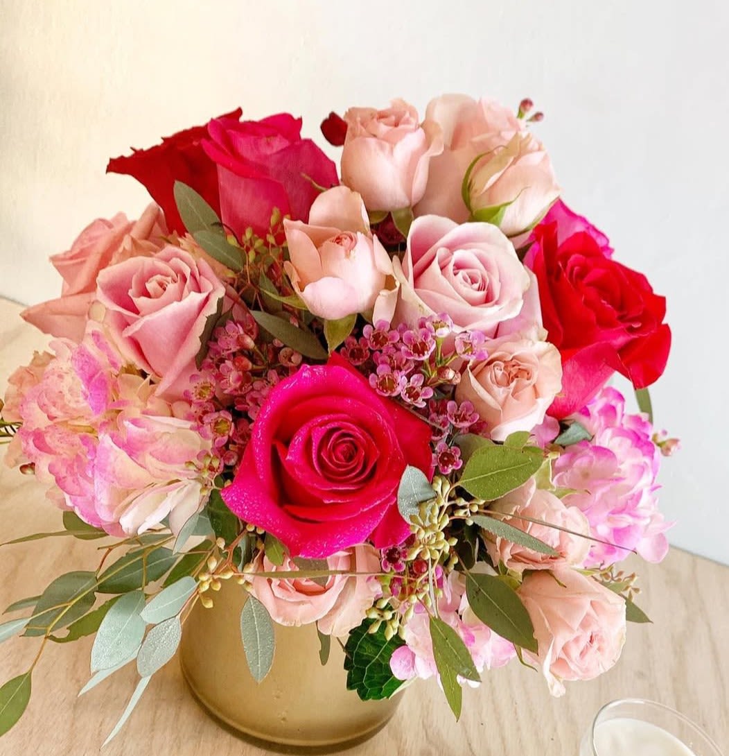 Sweet in Pink - Sweet in Pink is a delicate and charming floral arrangement designed in vibrant and soft pink tones. It features hot pink roses, blush spray roses, fresh hydrangeas, and soft seeded eucalyptus, creating a lush composition full of texture, freshness, and elegance. This design conveys sweetness, romance, and joy—perfect for celebrating special moments with a feminine and sophisticated touch.
