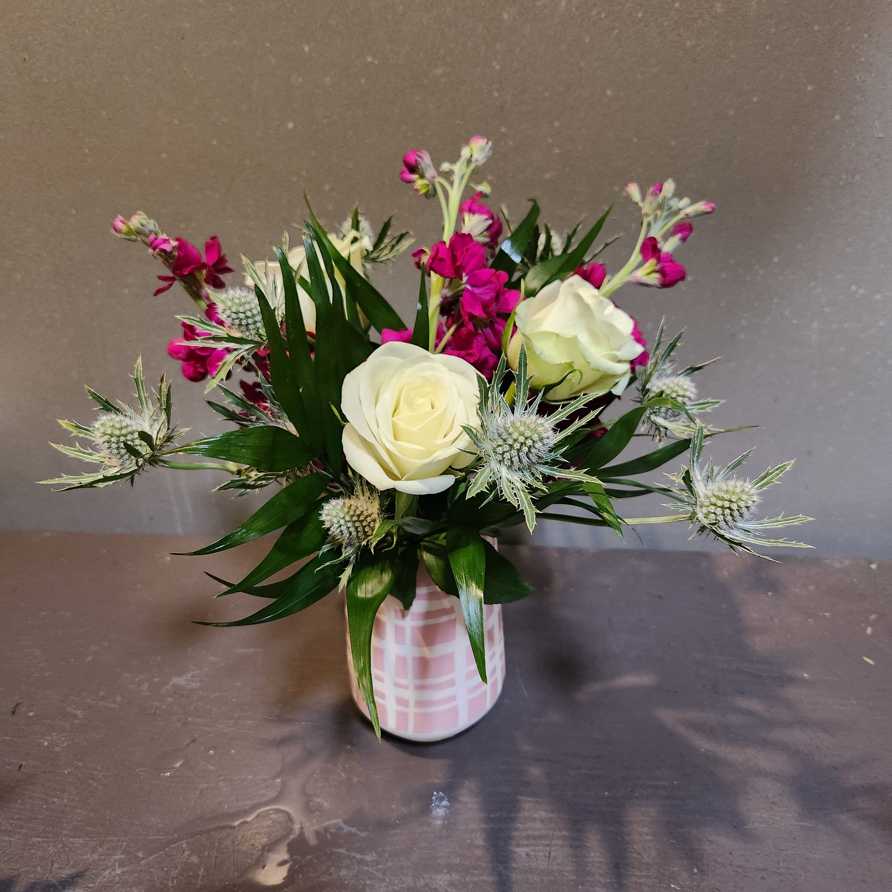 Think Pink! - A sweet bouquet to really brighten your day!  Measures approx. 12"Tx10"W and arrives in a plaid ceramic vase.