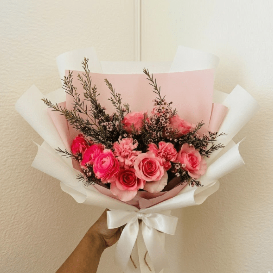 Rose Quartz - Lush, dense, and luxurious—Rose Quartz is a symphony of premium pink tones inspired by the stone of unconditional love. The pairing of roses and ranunculus provides a heavy, high-value feel that represents the fullness of your commitment.  This seasonal bouquet features:  Premium Light Pink Roses  Hot Pink Ranunculus  Starry Pink Waxflower  Garden Greens  Presentation: Expertly wrapped in our signature textured paper and tied with satin ribbon. Prefer a vase? Add one to your cart to complete the look.  Personal Touch: We’ll include a custom card message with every order. You’ll be able to write your message at checkout.  Please Note: All flowers are subject to seasonal availability. If a specific bloom isn’t available, our designers will thoughtfully substitute with flowers in a similar shape, style, and color.  Standard size shown. Vase upgrade is optional.   Floral Care Guide  Your arrangement arrives in our signature "double wrap" and is nestled in a protective box. While the stems are secured with a wet wrap for transit they are ready for a full drink!   Unpack: Gently lift the bouquet from the box. Remove the plastic bag and wet towel from the stems. Trim &amp; Hydrate: Trim 1/2" off stems at an angle and place in a clean vase with cool water. Refreshed: Change water daily for a long-lasting bloom.  