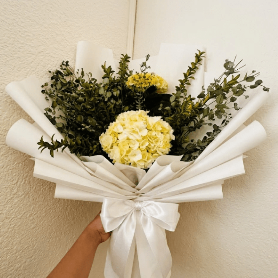 Peaceful White - Calm, elegant, and pure—Peaceful White offers a sense of serenity during difficult times. Lush white hydrangeas and noble snapdragons provide a comforting, timeless presence that honors a beautiful legacy.  This seasonal bouquet features:  White Hydrangea  Silvery Gunni Eucalyptus  Fresh Boxwood  Garden Greens  Presentation: Expertly wrapped in our signature textured paper and tied with satin ribbon. Prefer a vase? Add one to your cart to complete the look.  Personal Touch: We’ll include a custom card message with every order. You’ll be able to write your message at checkout.  Please Note: All flowers are subject to seasonal availability. If a specific bloom isn’t available, our designers will thoughtfully substitute with flowers in a similar shape, style, and color.  Standard size shown. Vase upgrade is optional.   Floral Care Guide  Your arrangement arrives in our signature "double wrap" and is nestled in a protective box. While the stems are secured with a wet wrap for transit they are ready for a full drink!   Unpack: Gently lift the bouquet from the box. Remove the plastic bag and wet towel from the stems. Trim &amp; Hydrate: Trim 1/2" off stems at an angle and place in a clean vase with cool water. Refreshed: Change water daily for a long-lasting bloom.  
