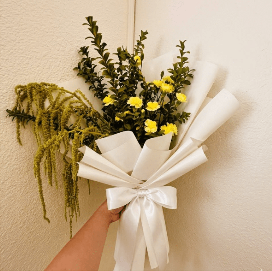 Vitality - Bold, resilient, and full of life—Vitality is a floral symbol of strength. Zesty yellow carnations and trailing amaranthus create a sense of movement and energy to cheer someone on toward health.  This seasonal bouquet features:  Yellow Mini Carnations  Green Hanging Amaranthus  Fresh Boxwood  Garden Greens   Presentation: Expertly wrapped in our signature textured paper and tied with satin ribbon. Prefer a vase? Add one to your cart to complete the look.  Personal Touch: We’ll include a custom card message with every order. You’ll be able to write your message at checkout.  Please Note: All flowers are subject to seasonal availability. If a specific bloom isn’t available, our designers will thoughtfully substitute with flowers in a similar shape, style, and color.  Standard size shown. Vase upgrade is optional.   Floral Care Guide  Your arrangement arrives in our signature "double wrap" and is nestled in a protective box. While the stems are secured with a wet wrap for transit they are ready for a full drink!   Unpack: Gently lift the bouquet from the box. Remove the plastic bag and wet towel from the stems. Trim &amp; Hydrate: Trim 1/2" off stems at an angle and place in a clean vase with cool water. Refreshed: Change water daily for a long-lasting bloom.  
