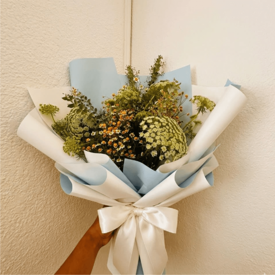 Meadow Breeze - Airy, graceful, and cool—Meadow Breeze feels like a spring wind through an open window. The delicate textures of Queen Anne’s Lace and feverfew are unpretentious and soothing for a slow recovery.  This seasonal bouquet features:  Queen Anne’s Lace  Petite White Feverfew  Fresh Boxwood  Garden Greens  Presentation: Expertly wrapped in our signature textured paper and tied with satin ribbon. Prefer a vase? Add one to your cart to complete the look.  Personal Touch: We’ll include a custom card message with every order. You’ll be able to write your message at checkout.  Please Note: All flowers are subject to seasonal availability. If a specific bloom isn’t available, our designers will thoughtfully substitute with flowers in a similar shape, style, and color.  Standard size shown. Vase upgrade is optional.   Floral Care Guide  Your arrangement arrives in our signature "double wrap" and is nestled in a protective box. While the stems are secured with a wet wrap for transit they are ready for a full drink!   Unpack: Gently lift the bouquet from the box. Remove the plastic bag and wet towel from the stems. Trim &amp; Hydrate: Trim 1/2" off stems at an angle and place in a clean vase with cool water. Refreshed: Change water daily for a long-lasting bloom.  