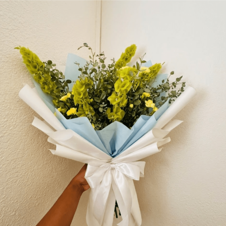 Spring Tonic - Vibrant, fresh, and growing—Spring Tonic is a natural boost for the spirit. Upright green bells of Ireland and bright yellow carnations symbolize a return to wellness and strength.  This seasonal bouquet features:  Bells of Ireland  Yellow Mini Carnations  Silvery Gunni Eucalyptus  Garden Greens   Presentation: Expertly wrapped in our signature textured paper and tied with satin ribbon. Prefer a vase? Add one to your cart to complete the look.  Personal Touch: We’ll include a custom card message with every order. You’ll be able to write your message at checkout.  Please Note: All flowers are subject to seasonal availability. If a specific bloom isn’t available, our designers will thoughtfully substitute with flowers in a similar shape, style, and color.  Standard size shown. Vase upgrade is optional.   Floral Care Guide  Your arrangement arrives in our signature "double wrap" and is nestled in a protective box. While the stems are secured with a wet wrap for transit they are ready for a full drink!   Unpack: Gently lift the bouquet from the box. Remove the plastic bag and wet towel from the stems. Trim &amp; Hydrate: Trim 1/2" off stems at an angle and place in a clean vase with cool water. Refreshed: Change water daily for a long-lasting bloom.  