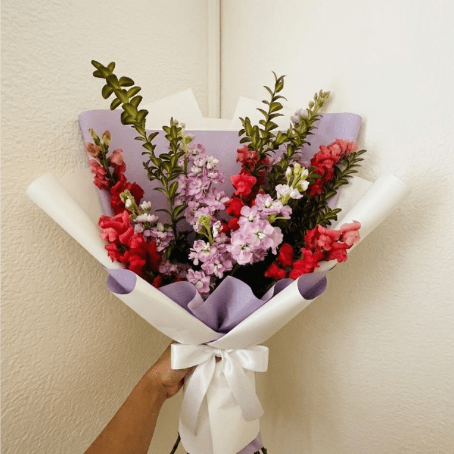 Stellar - Vibrant, high-impact, and fragrant—Stellar is designed to celebrate the star in your life. Hot pink snapdragons and lavender stock create a bold arrangement that commands attention and inspires joy.  This seasonal bouquet features:  Hot Pink Snapdragons  Lavender Stock  Fresh Boxwood  Garden Greens  Presentation: Expertly wrapped in our signature textured paper and tied with satin ribbon. Prefer a vase? Add one to your cart to complete the look.  Personal Touch: We’ll include a custom card message with every order. You’ll be able to write your message at checkout.  Please Note: All flowers are subject to seasonal availability. If a specific bloom isn’t available, our designers will thoughtfully substitute with flowers in a similar shape, style, and color.  Standard size shown. Vase upgrade is optional.   Floral Care Guide  Your arrangement arrives in our signature "double wrap" and is nestled in a protective box. While the stems are secured with a wet wrap for transit they are ready for a full drink!   Unpack: Gently lift the bouquet from the box. Remove the plastic bag and wet towel from the stems. Trim &amp; Hydrate: Trim 1/2" off stems at an angle and place in a clean vase with cool water. Refreshed: Change water daily for a long-lasting bloom.  