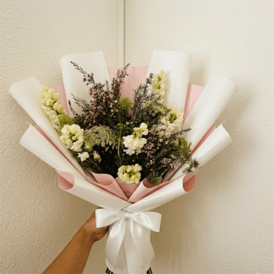 Cloud Nine - Ethereal, light, and peaceful—Cloud Nine feels like a dream realized. This simple, all-white arrangement of snapdragons and Queen Anne’s Lace is an elegant and beautiful gesture to celebrate a new beginning.  This seasonal bouquet features:  White Snapdragons  Queen Anne’s Lace  Starry Pink Waxflower  Garden Greens  Presentation: Expertly wrapped in our signature textured paper and tied with satin ribbon. Prefer a vase? Add one to your cart to complete the look.  Personal Touch: We’ll include a custom card message with every order. You’ll be able to write your message at checkout.  Please Note: All flowers are subject to seasonal availability. If a specific bloom isn’t available, our designers will thoughtfully substitute with flowers in a similar shape, style, and color.  Standard size shown. Vase upgrade is optional.   Floral Care Guide  Your arrangement arrives in our signature "double wrap" and is nestled in a protective box. While the stems are secured with a wet wrap for transit they are ready for a full drink!   Unpack: Gently lift the bouquet from the box. Remove the plastic bag and wet towel from the stems. Trim &amp; Hydrate: Trim 1/2" off stems at an angle and place in a clean vase with cool water. Refreshed: Change water daily for a long-lasting bloom.  