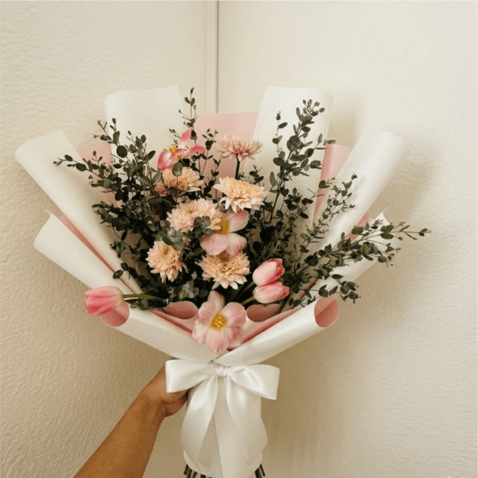 Pastel Picnic - Joyful, warm, and inviting—Pastel Picnic celebrates a new addition with a burst of spring color. Peach mums and pink tulips create a friendly, seasonal look that is perfect for a celebratory home delivery.  This seasonal bouquet features:  Peach Mums  Pink Tulips  Silvery Gunni Eucalyptus  Garden Greens  Presentation: Expertly wrapped in our signature textured paper and tied with satin ribbon. Prefer a vase? Add one to your cart to complete the look.  Personal Touch: We’ll include a custom card message with every order. You’ll be able to write your message at checkout.  Please Note: All flowers are subject to seasonal availability. If a specific bloom isn’t available, our designers will thoughtfully substitute with flowers in a similar shape, style, and color.  Standard size shown. Vase upgrade is optional.   Floral Care Guide  Your arrangement arrives in our signature "double wrap" and is nestled in a protective box. While the stems are secured with a wet wrap for transit they are ready for a full drink!   Unpack: Gently lift the bouquet from the box. Remove the plastic bag and wet towel from the stems. Trim &amp; Hydrate: Trim 1/2" off stems at an angle and place in a clean vase with cool water. Refreshed: Change water daily for a long-lasting bloom.  