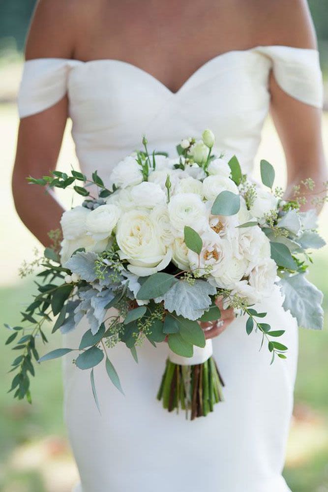 Classic White Rose Bridal Bouquet - A classic and elegant bridal bouquet featuring lush white roses, soft ranunculus, and fresh eucalyptus greenery. Designed with a natural, romantic style, this bouquet is perfect for timeless weddings and refined bridal looks.  Handcrafted with premium blooms, it creates a soft, airy, and sophisticated statement for your special day.