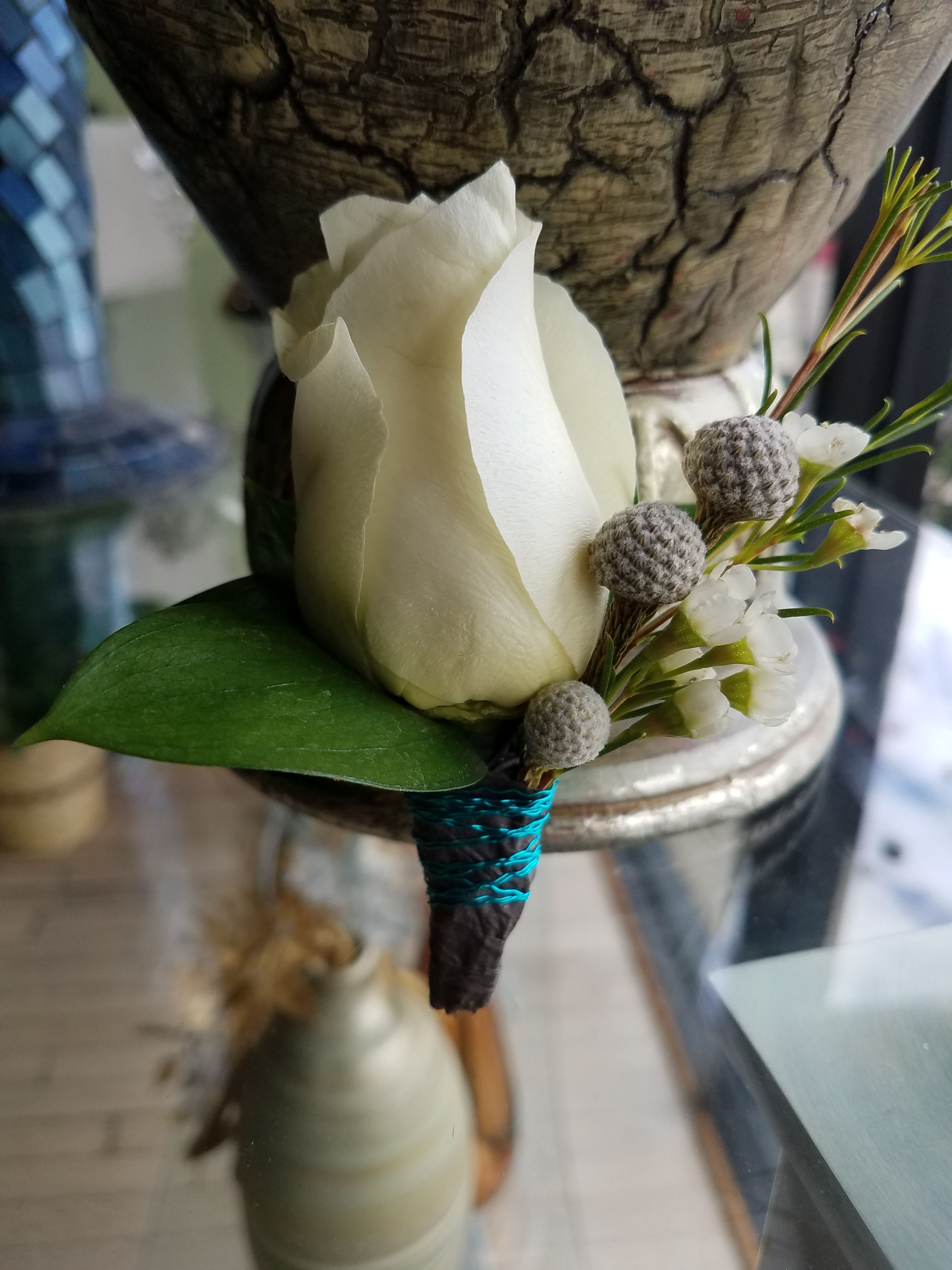Classic White Rose Boutonniere - A classic and elegant boutonniere featuring a white rose accented with delicate greenery and natural textures.  Designed for grooms and wedding party members, this piece adds a refined and timeless touch to any wedding look. Each boutonniere is handcrafted for a clean, sophisticated finish.