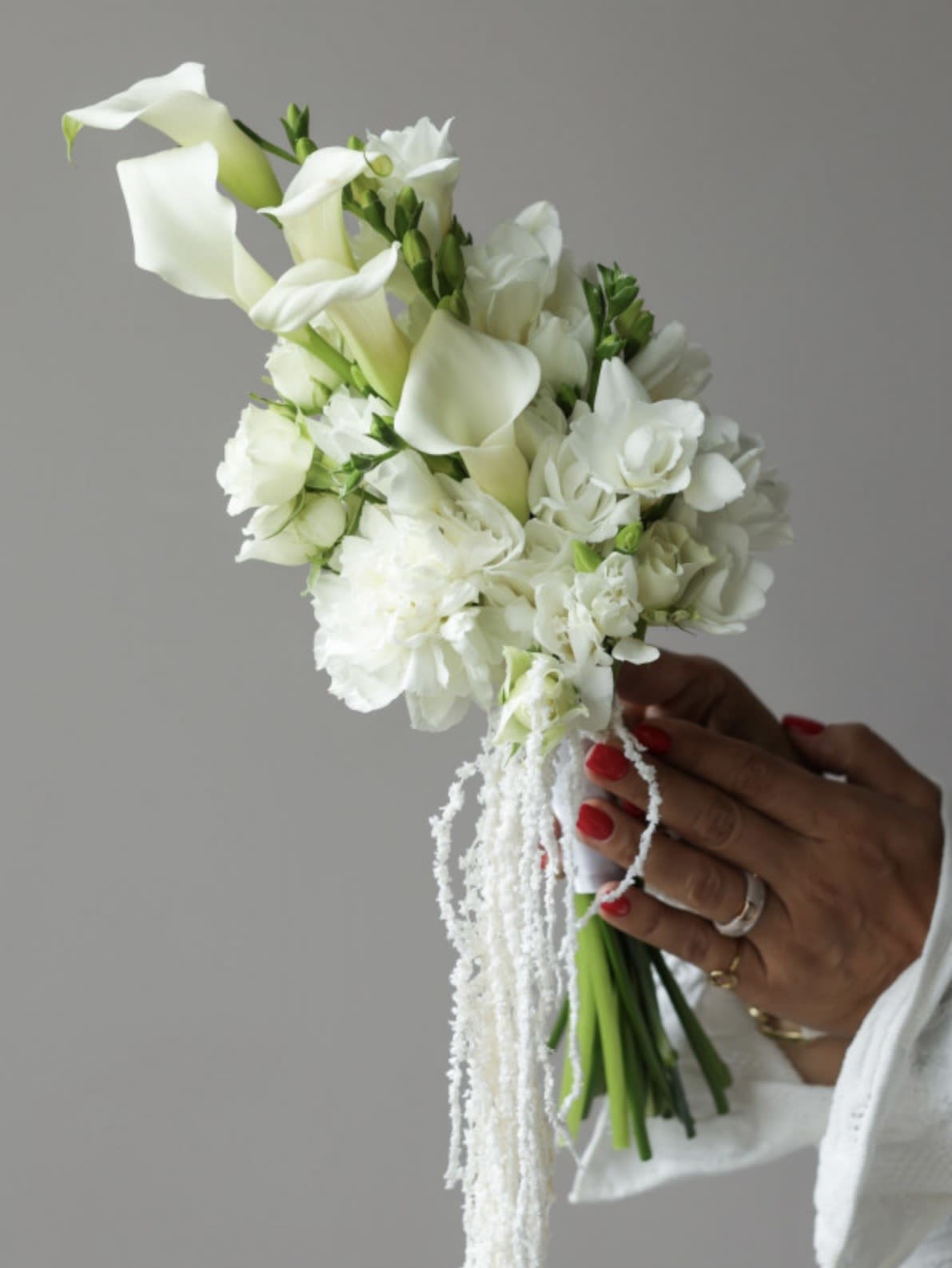 Modern Calla Lily Bridal Bouquet - A modern and elegant bridal bouquet featuring graceful white calla lilies, soft blooms, and delicate cascading accents.  Designed with a refined, elongated silhouette, this bouquet creates a sophisticated and fashion-forward bridal look. Perfect for contemporary and elegant weddings, each arrangement is handcrafted to achieve a clean and luxurious finish.
