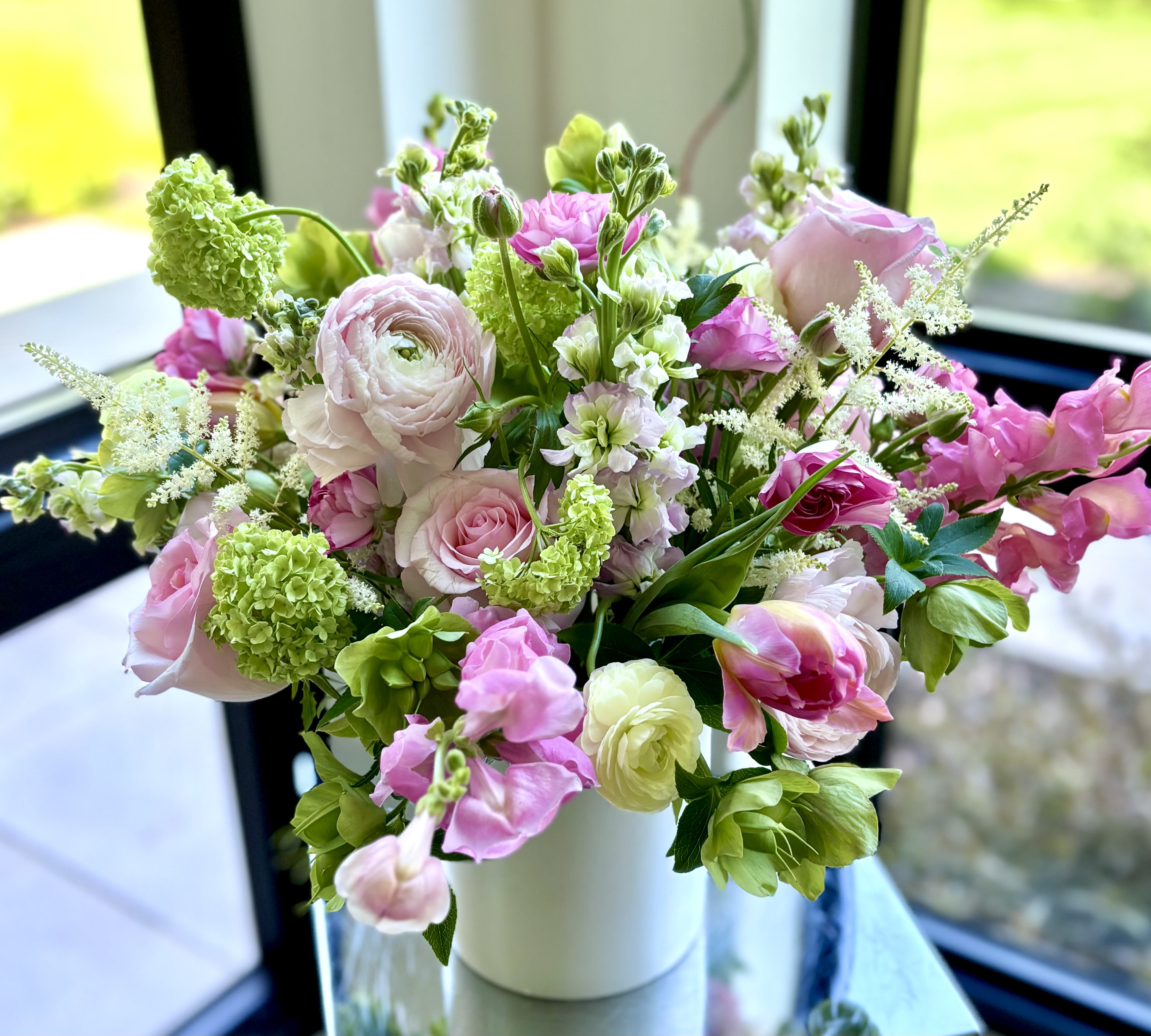 Pink Lemonade - A lovely flower arrangement with premium pink blooms, and green fillers like viburnum and hellebore is a perfect gift for those who love pink. A mix can vary but usually roses, tulips, snapdragons, ranunculus, stock, larkspur and lisianthus.