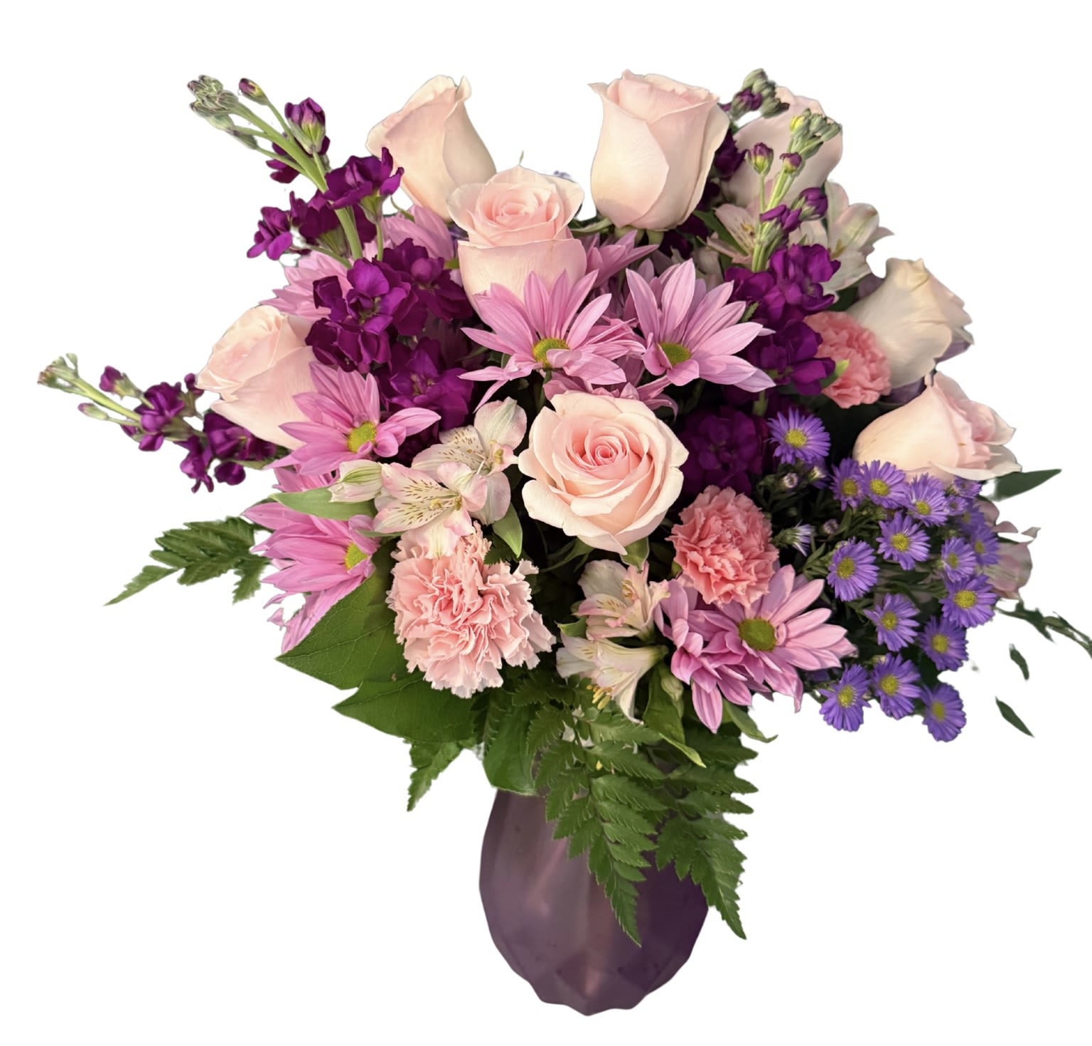 Soft blooms bouquet for mom - Pale pink roses and soft pink daisies mingle with fluffy carnations and sprigs of lavender-hued stock to create a gentle, feminine flower arrangement-perfect as a Mother's Day bouquet or a birthday surprise for the mom who loves romantic, pastel tones. The mix of blush and vivid purple accents reads cheerful and thoughtful; the person you're sending it to will feel seen and celebrated by the bouquet's tender color story and abundant, rounded shape.  This flower arrangement features alstroemeria, roses, carnations, daisies, and stock arranged with fern greenery for a lush, layered texture. The bouquet is presented in a purple vase that complements the lavender and purple blooms, giving the overall design a cohesive, elegant look. Sized to sit beautifully on a table or desk, it's a versatile gift for thank-you moments, spring celebrations, or simply to brighten her day; refresh the water every two days and trim stems at an angle to keep blooms looking their best.