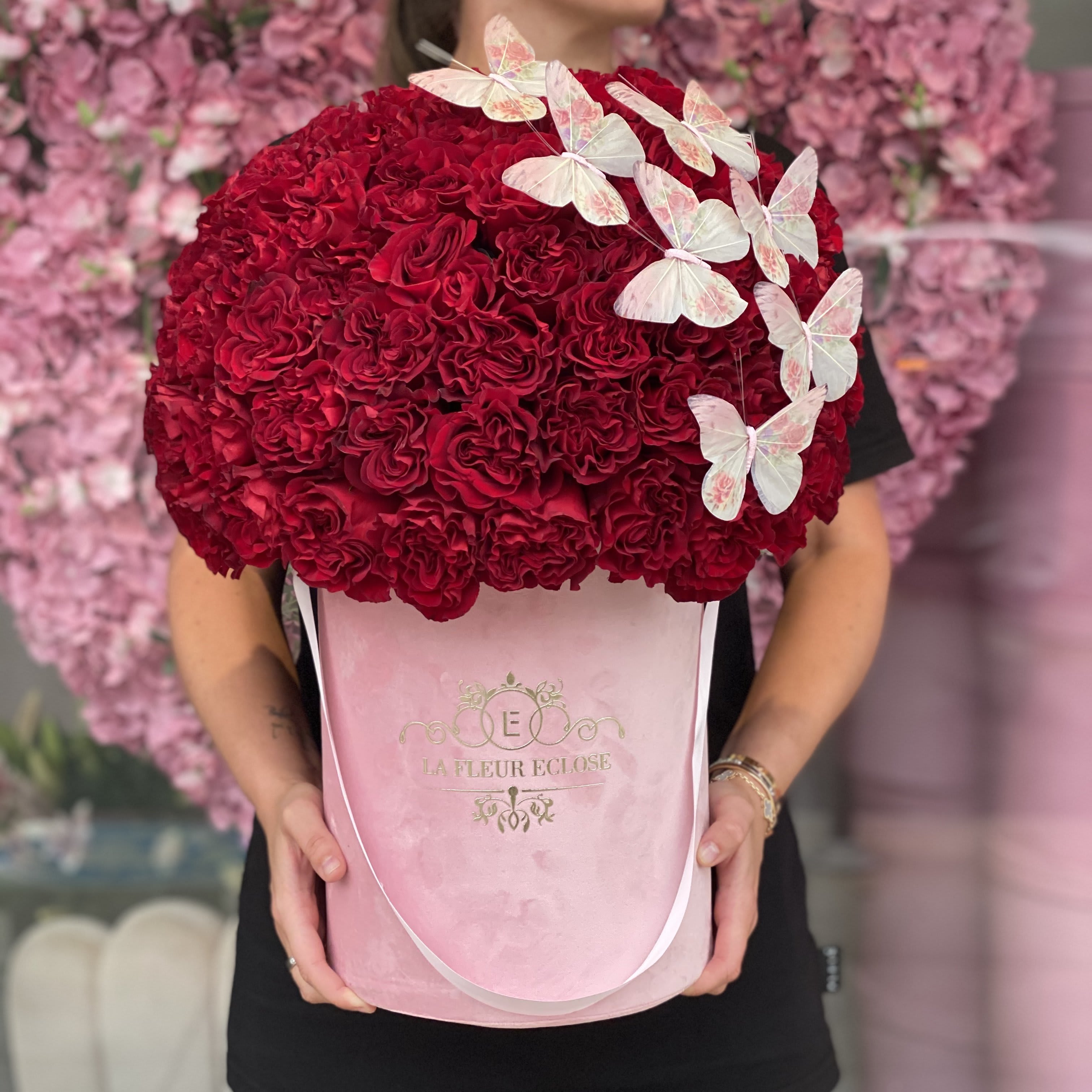Miss Pinks with Butterflies in Velvet V - FRESH CUT ROSES Standard 50 red roses in our signature velvet pink box  Deluxe 75  red roses in our signature velvet pink box  Premium 100 red roses NOTE; butterfly colors may vary 