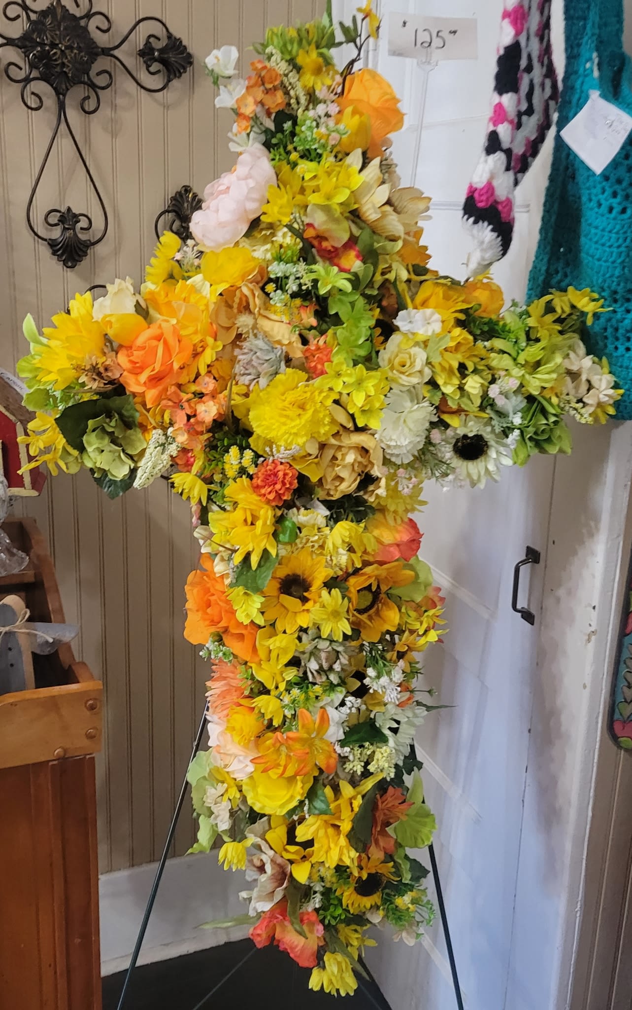 Sunshine Silk Cross - This grapevine cross is covered with silk florals in different shades of beautiful, trendy colors. Roses, hydrangeas , Peonies are just a few of the flowers used in this design. Perfect to hang on an accent wall. Bright, bold, and beautifully designed.