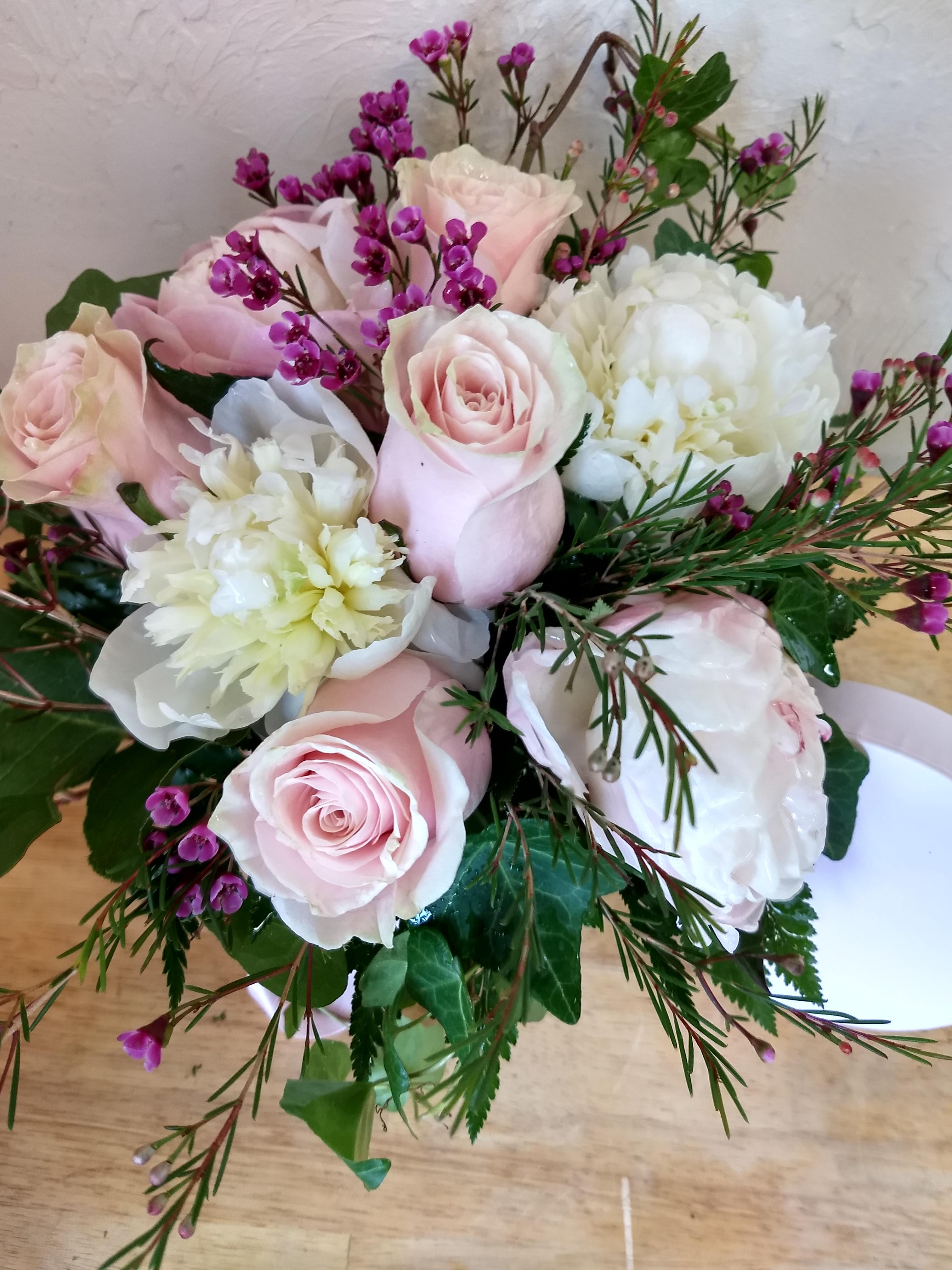 Pink roses and white blooms with purple filler flowers in a bouquet