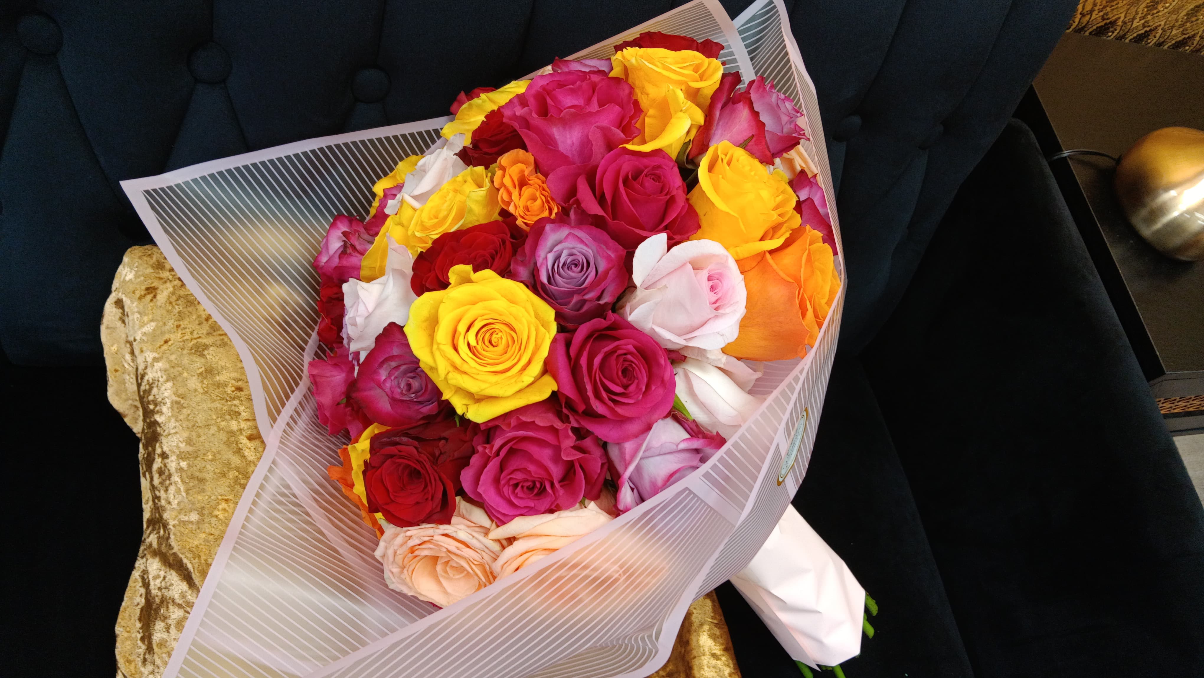 Bouquet of multicolored roses wrapped in striped paper