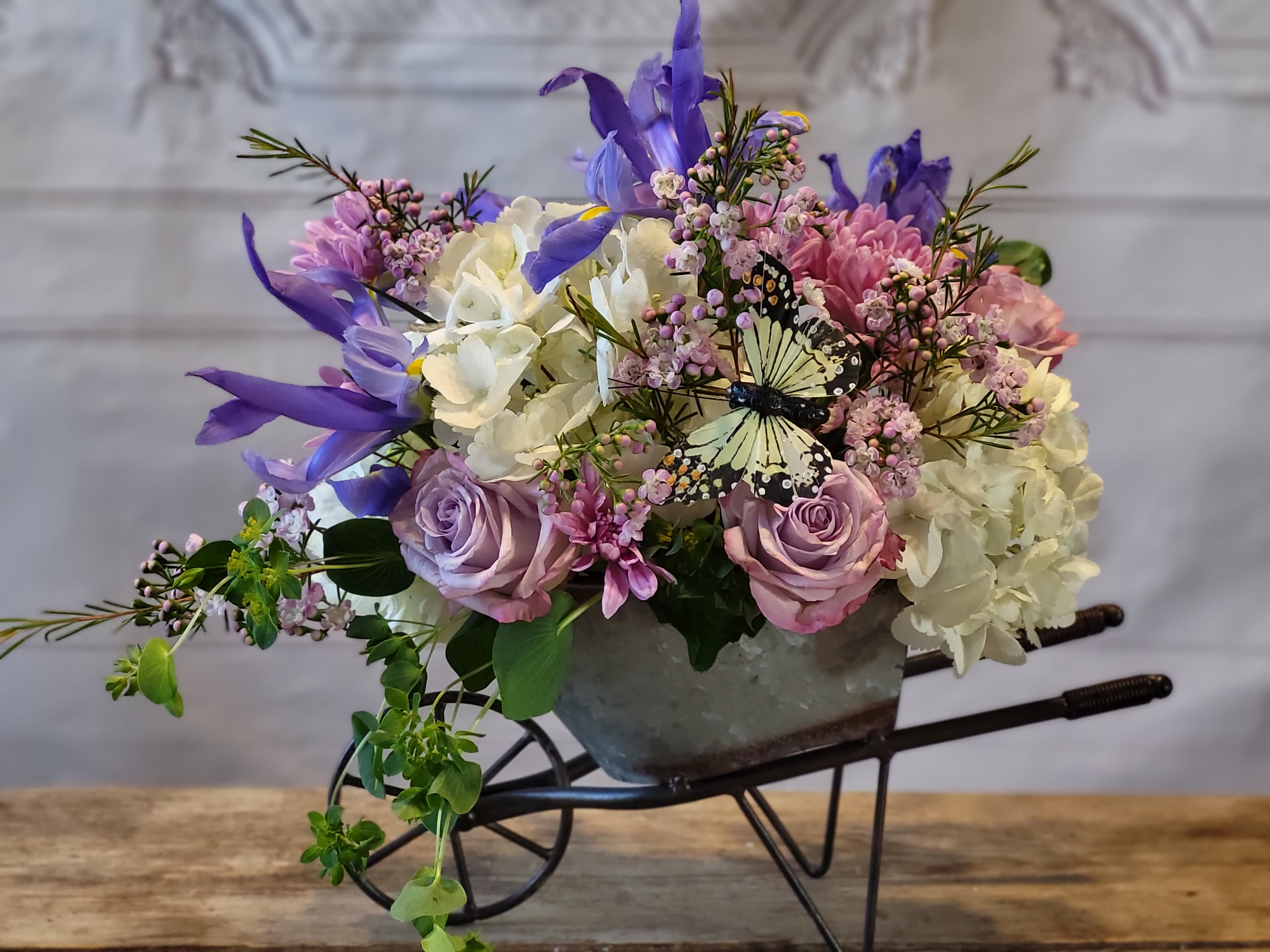 Mixed bouquet in a metal container with purple, pink, and white flowers