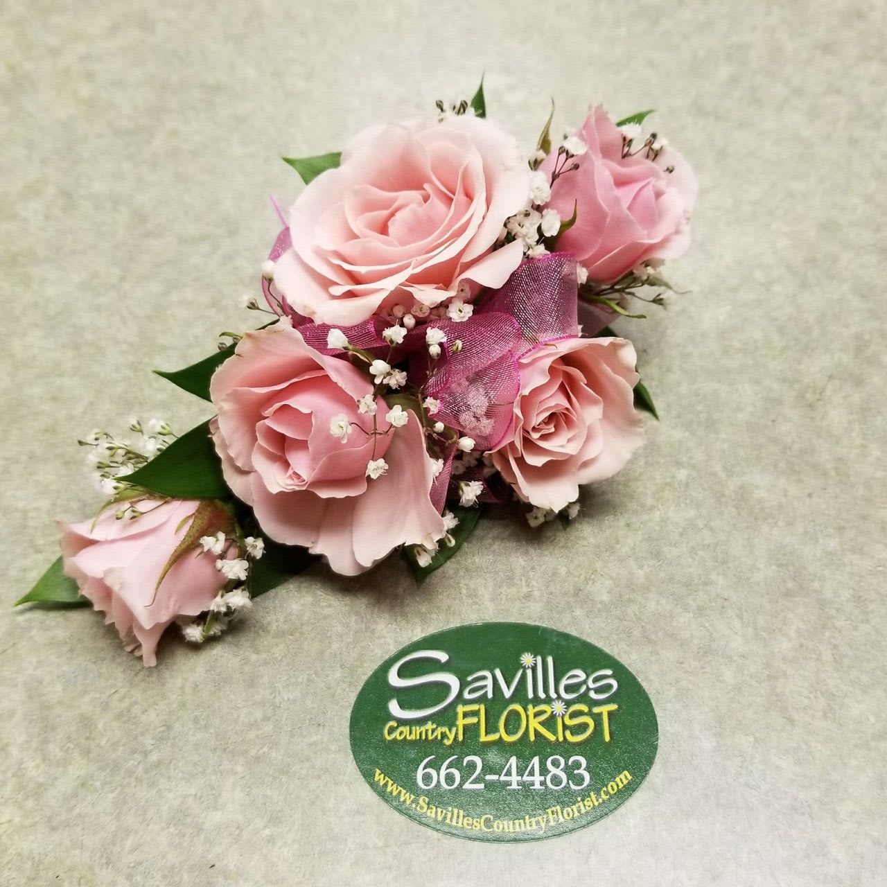 Small pink rose corsage with baby's breath and ribbon