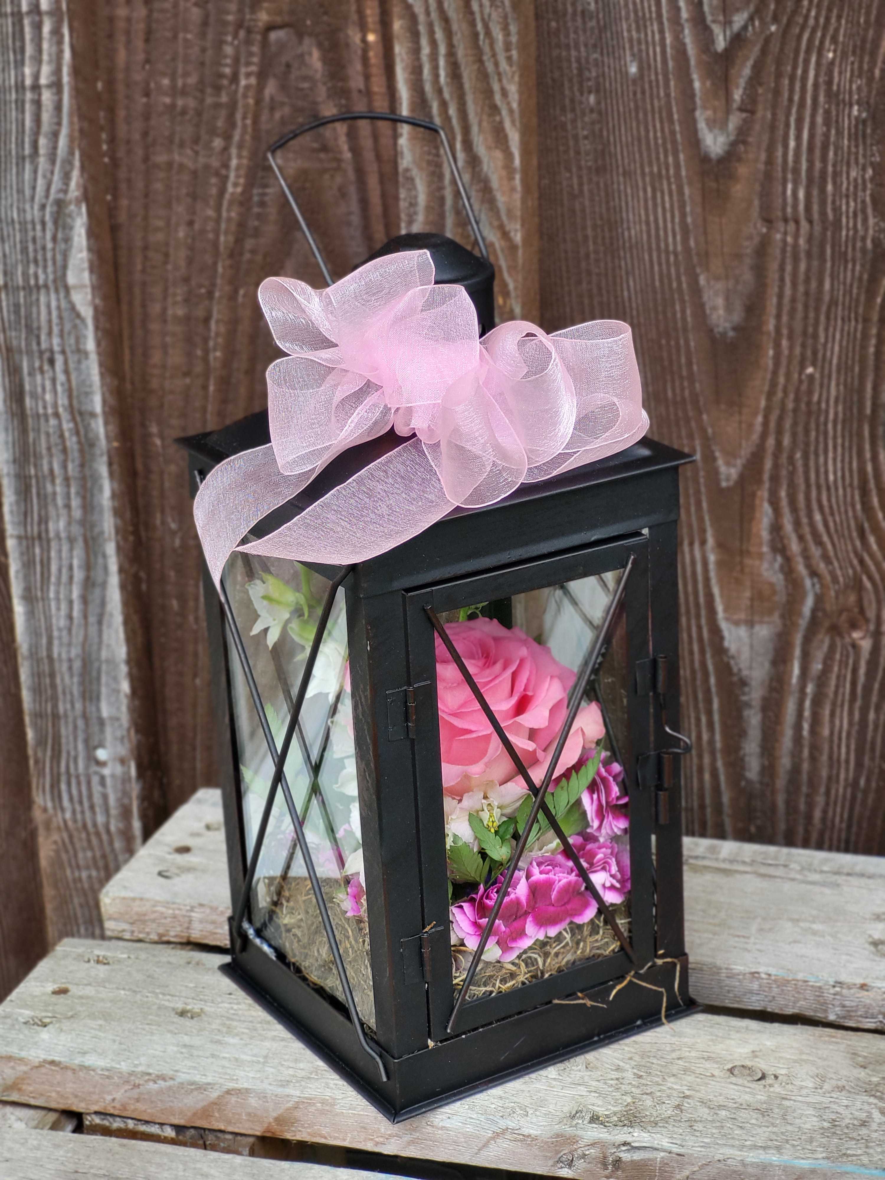 Black lantern with pink flowers and a pink bow