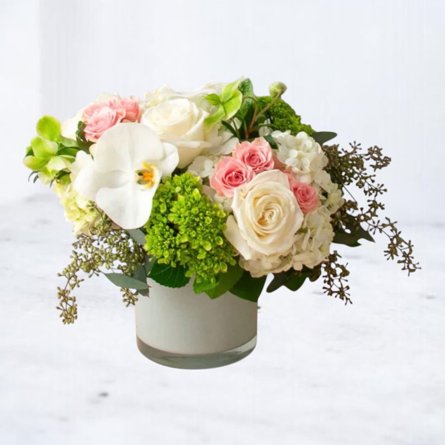 Ethereal Charm - Delicate and captivating, the Ethereal Charm is a harmonious blend of soft pink roses, creamy white orchids, and lush green accents. This beautiful arrangement, presented in an elegant vase, radiates sophistication and grace. Perfect for expressing love, celebrating milestones, or offering comfort, these blooms embody tranquility and refined beauty. Make any moment unforgettable with this serene floral masterpiece.