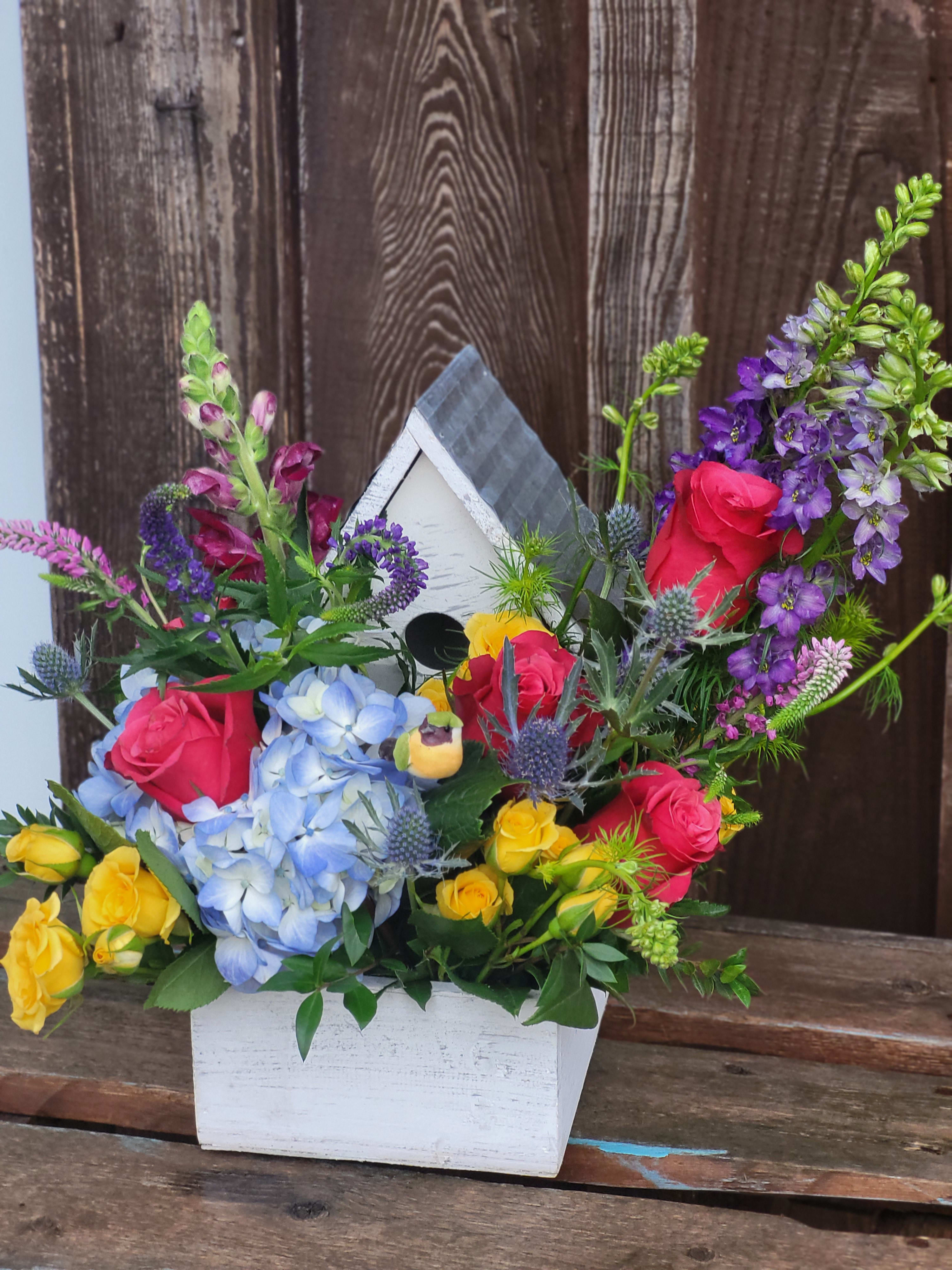 Spring in Full Bloom - A fun birdhouse planter overflowing with colorful flowers including roses, hydrangea, snapdragons, larkspur and more! Once the flowers have faded, this planter can be filled with live plants to enjoy for months to come!