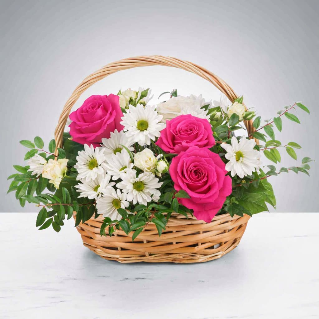 Pristine - The white daisies and pink roses in this basket arrangement is sure to bring joy!  Due to the current situation, supply is limited, therefore, color and variety substitutions may be necessary, please specify if you have a preferred color and we will do our best to accommodate your request.