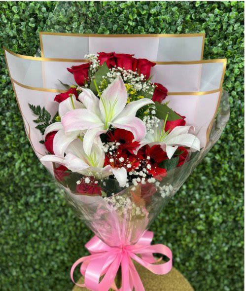 visions of love Bouquet 12 Red rouses with 3 Lilis - An elegant bouquet of 12 red roses and 3 lilies, wrapped in Korean-style paper—ideal for gifting to your favorite person on any occasion. The paper color may vary.