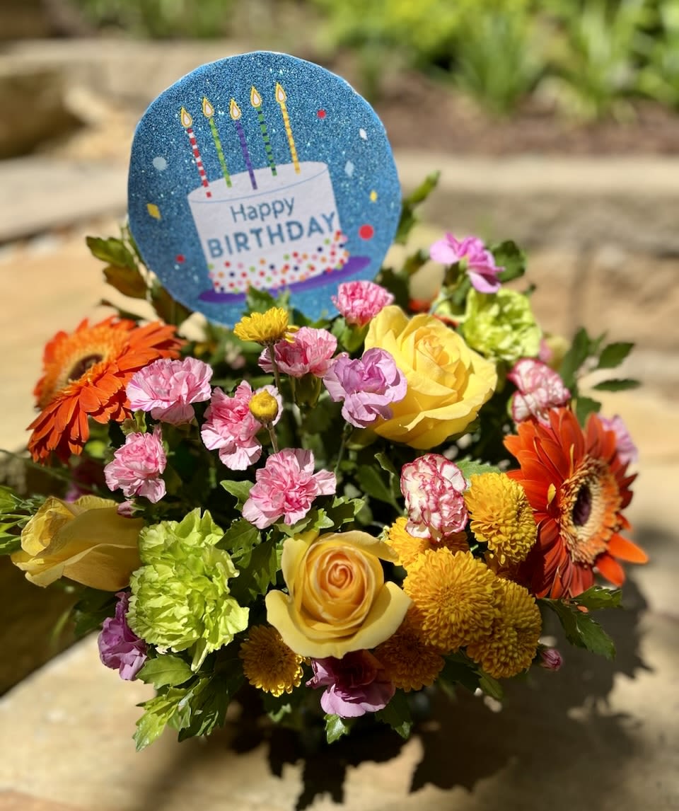 Birthday Beauty - A bright, compact arrangement made with shades of yellow, pink, orange and green flowers in a vase to be given on someone’s special day! 
