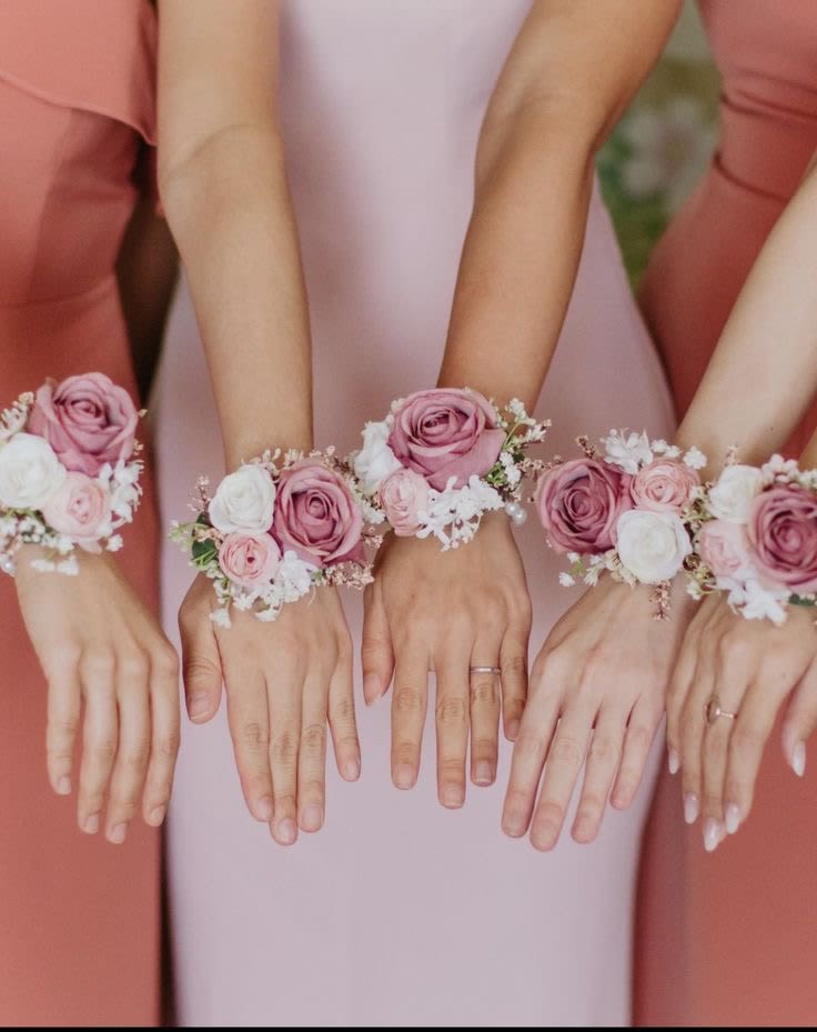 Bridesmaids wearing pink rose wrist corsages