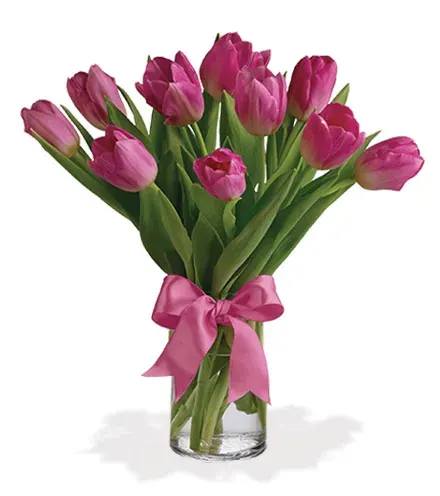 Pink tulips in a clear glass vase tied with a pink ribbon